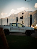 White pickup truck parked with mountains in background
