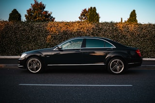 A black luxury sedan parked on the roadside.