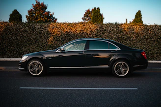 A black luxury sedan parked on the roadside.