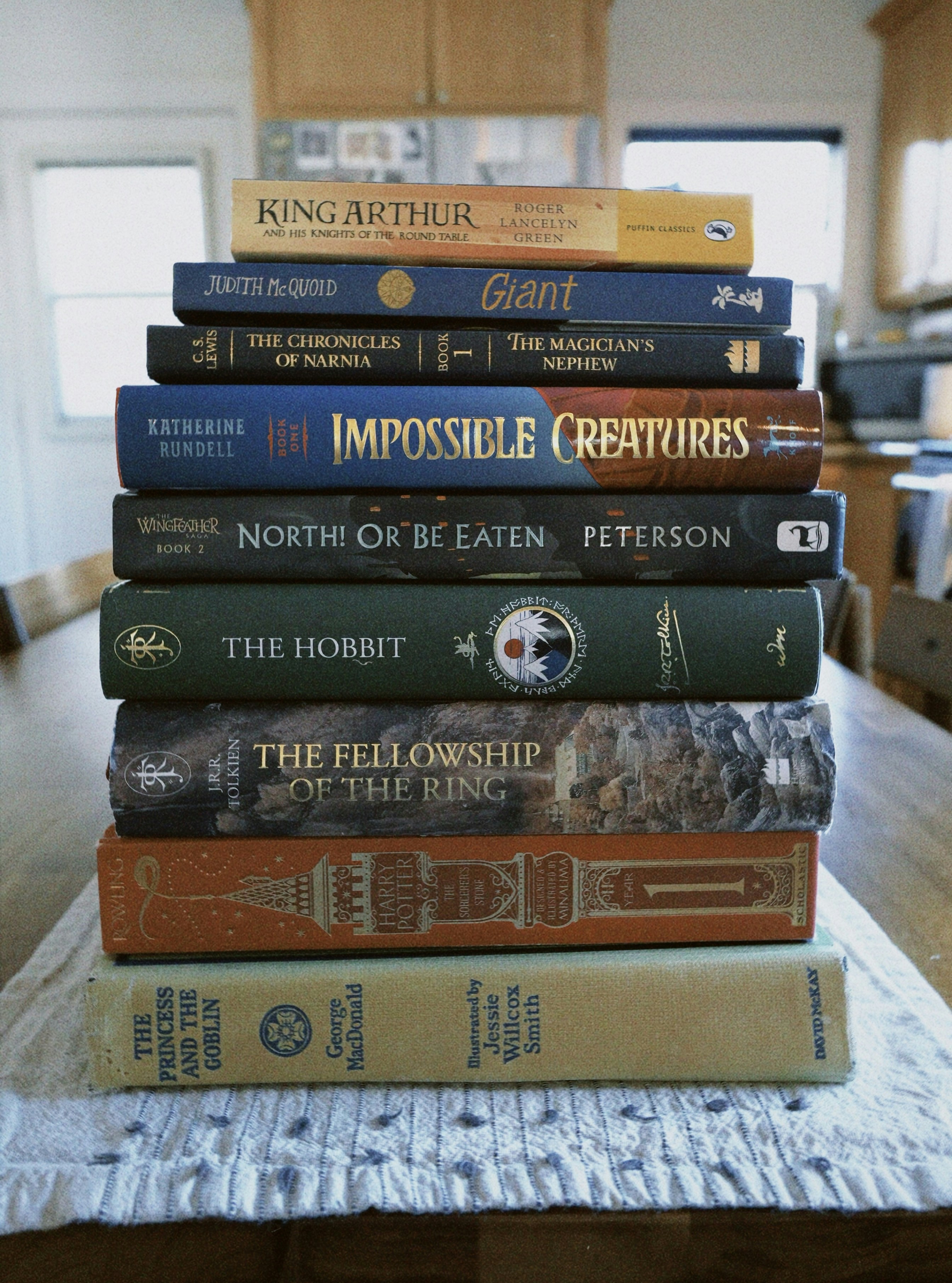 テーブルの上にはファンタジー小説の山が置かれている。