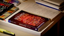 Research design book on a desk with notebooks.