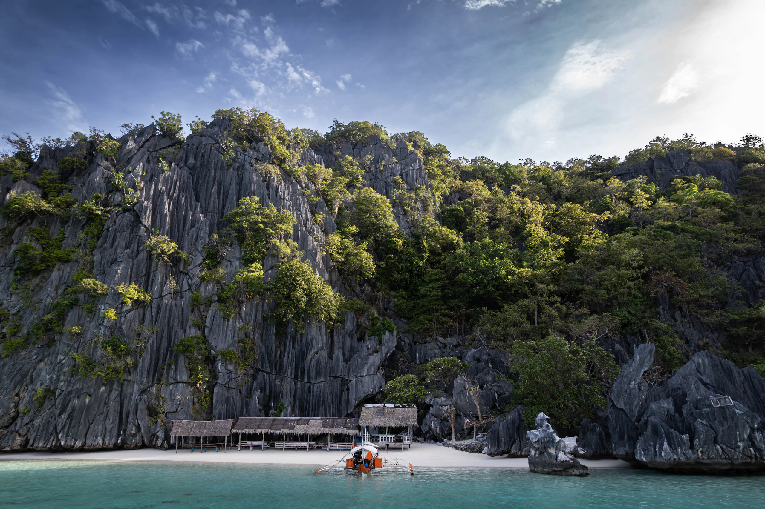 Small huts on a tropical island with rocky cliffs