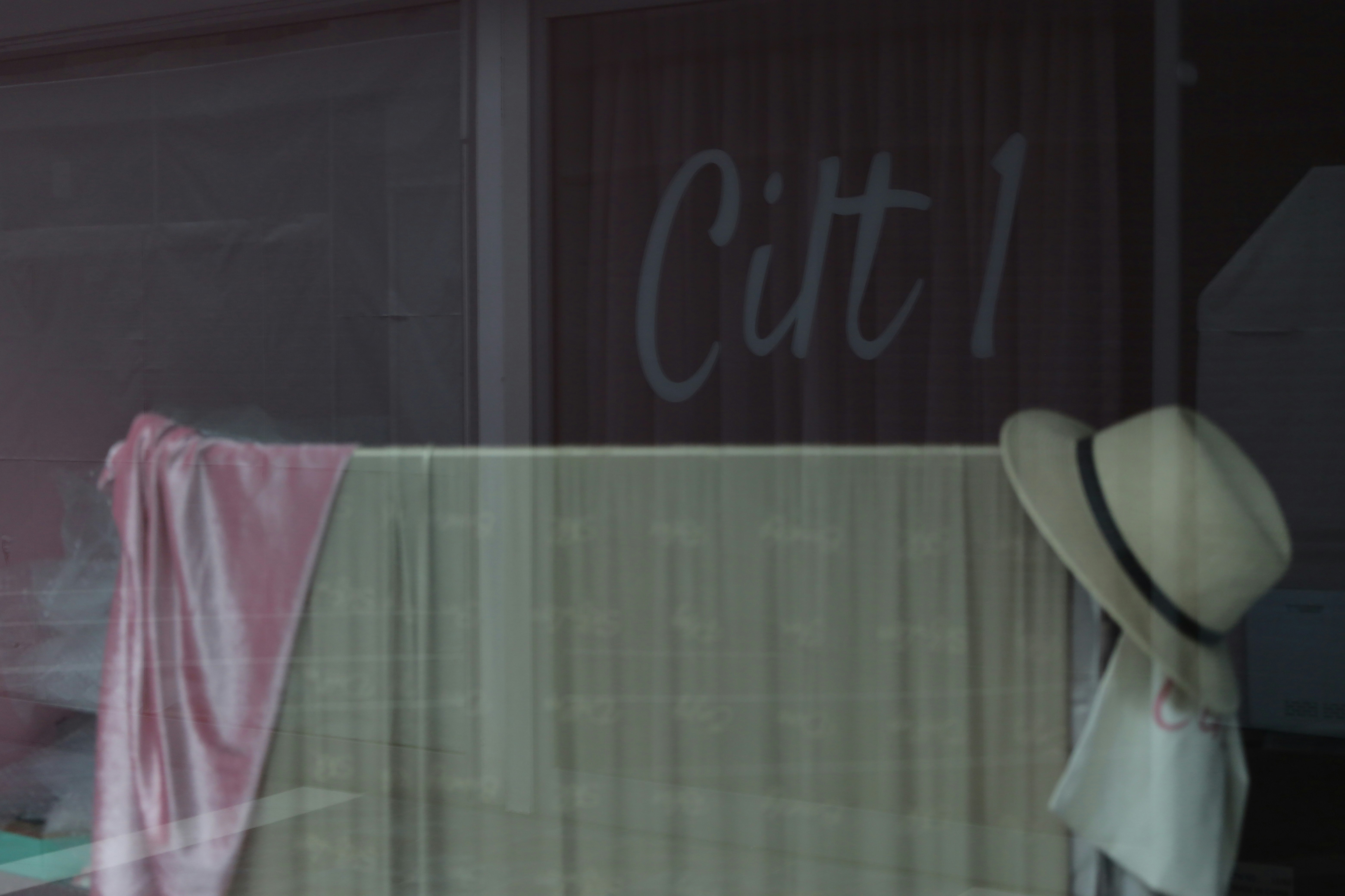 Straw hat and pink towel hanging on rack (Photo by Özlem Sümer on Unsplash)