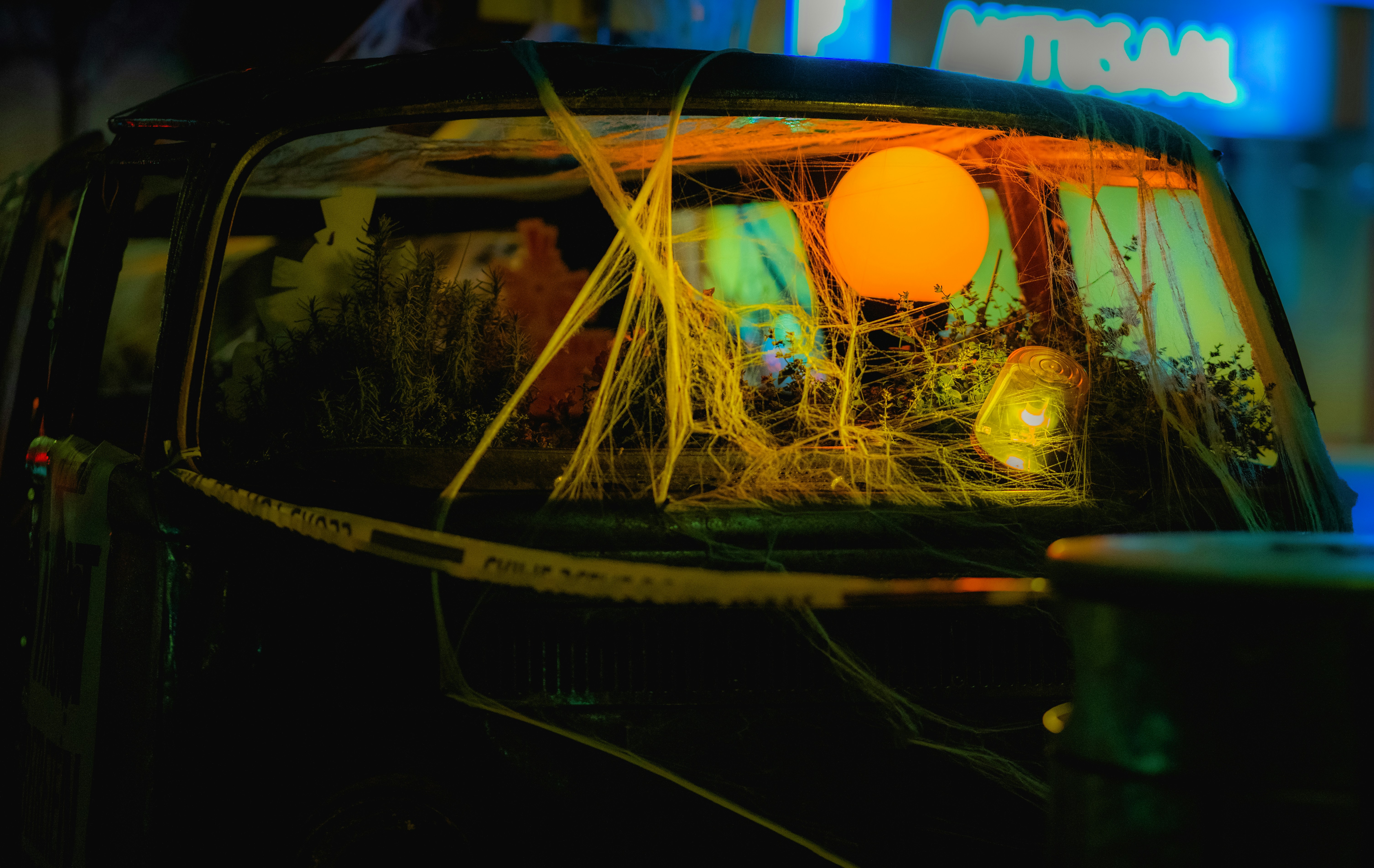 Orangefarbene Kugel spiegelt sich auf der Autoscheibe mit Spinnweben