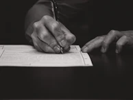 Hand writing with a fountain pen on paper.
