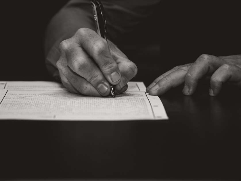 Person holding a pen over a legal document ready to sign a residential lease or property contract