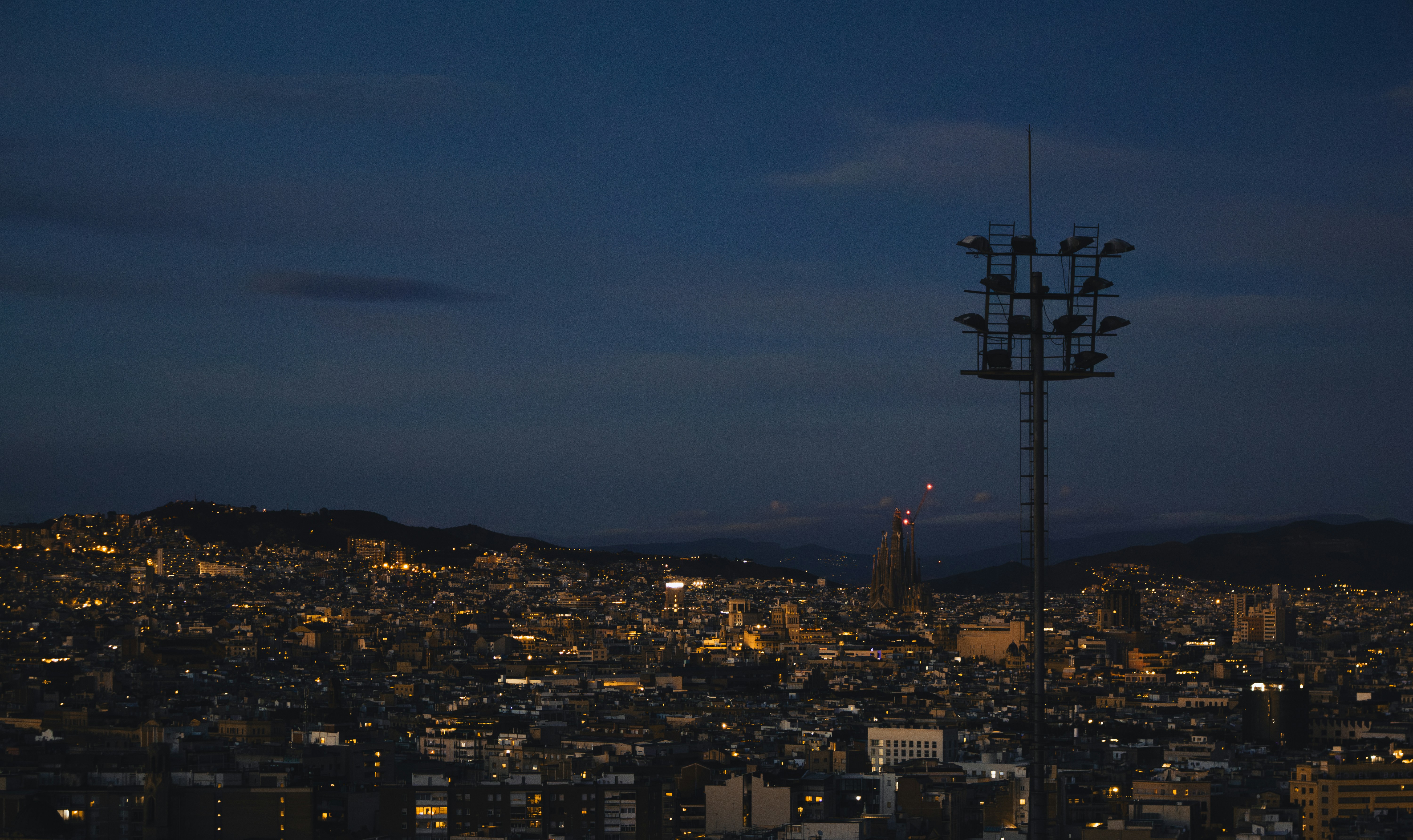 City lights illuminate the landscape at dusk.