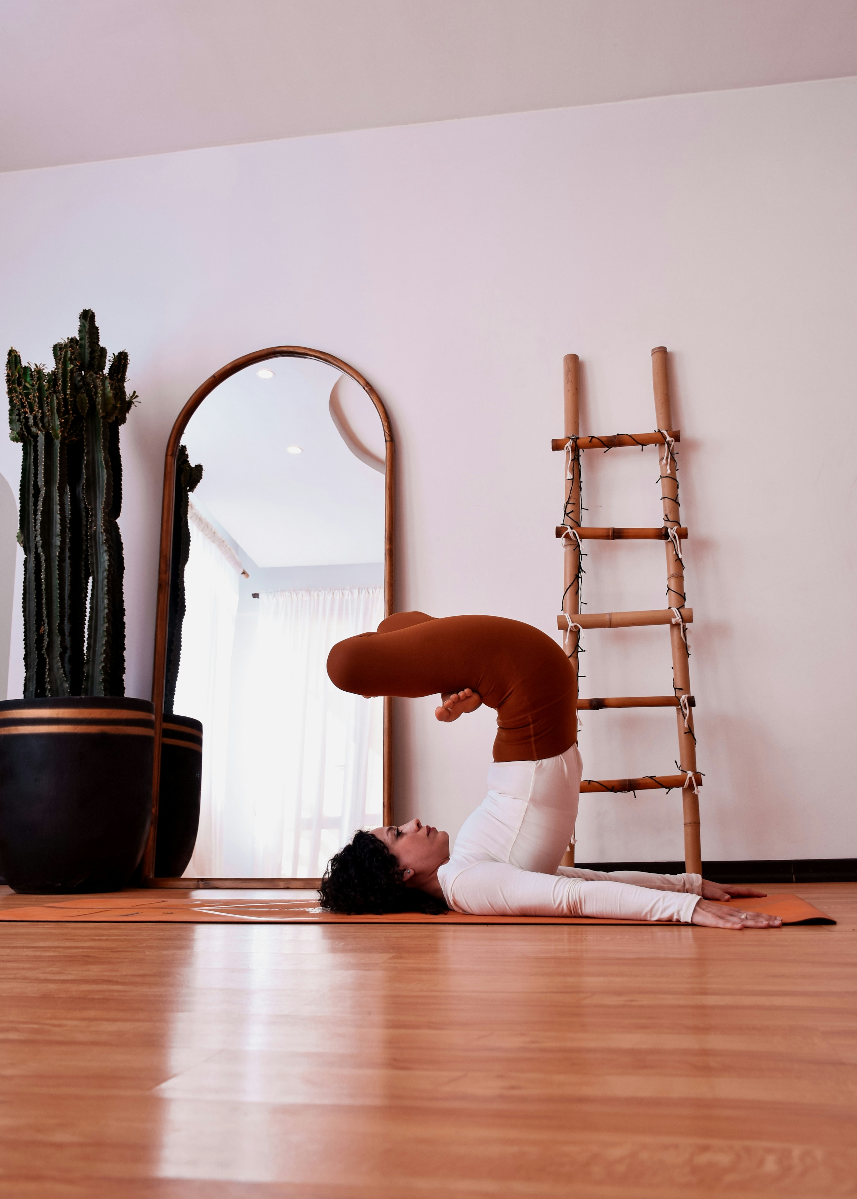 Woman performing yoga pose on mat in studio