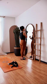 Woman applying makeup in a mirror with cat nearby