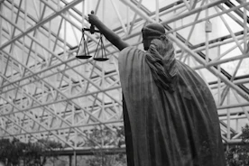 Statue of lady justice holding scales indoors