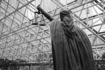 Statue of lady justice holding scales indoors