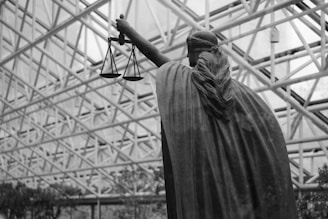 Statue of lady justice holding scales indoors