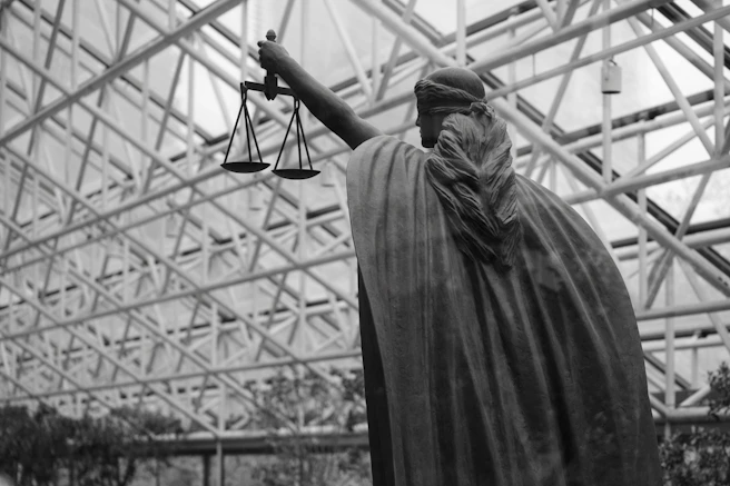 Statue of lady justice holding scales indoors