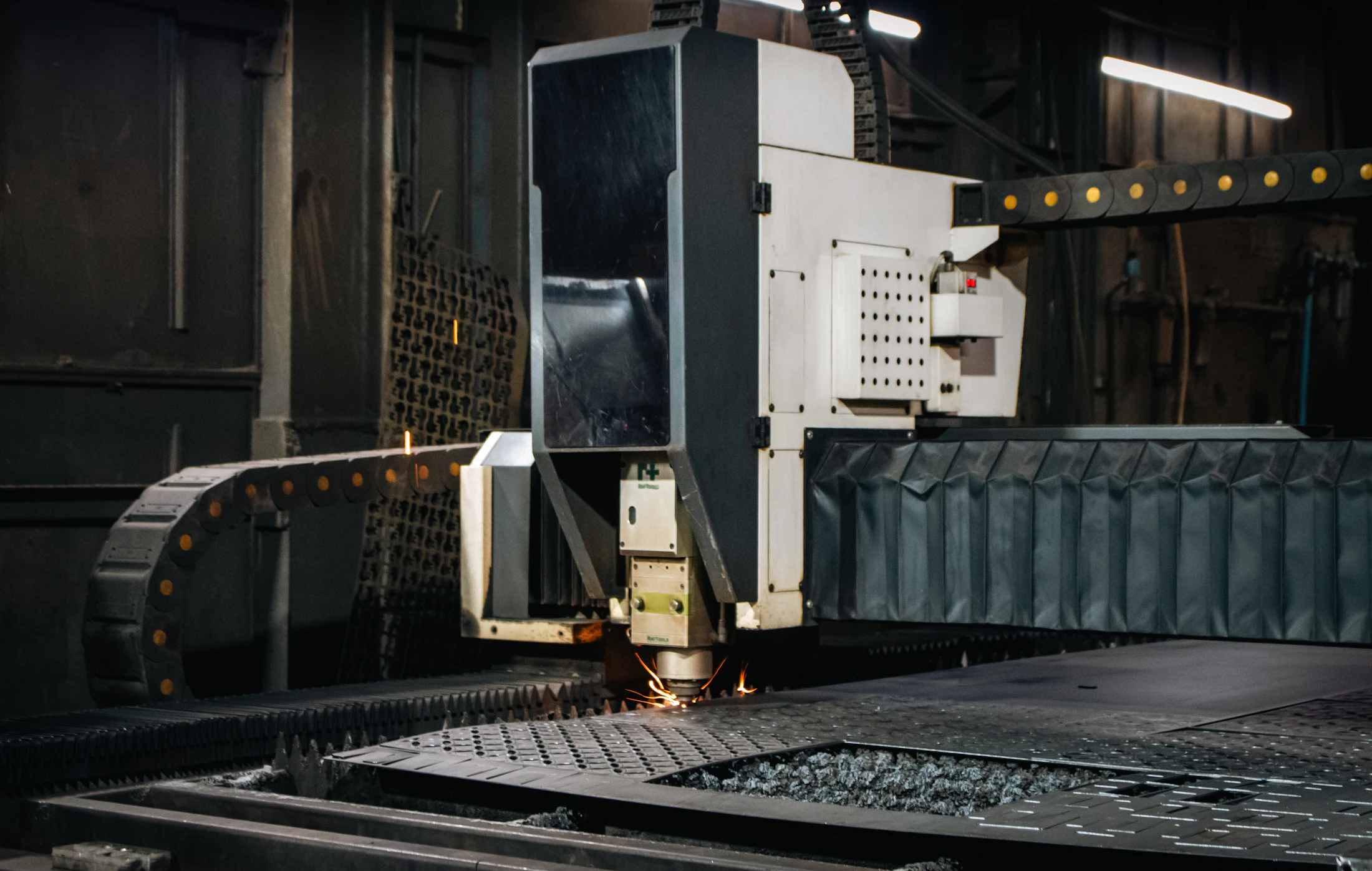 Industrial laser processing head working over a metal sheet