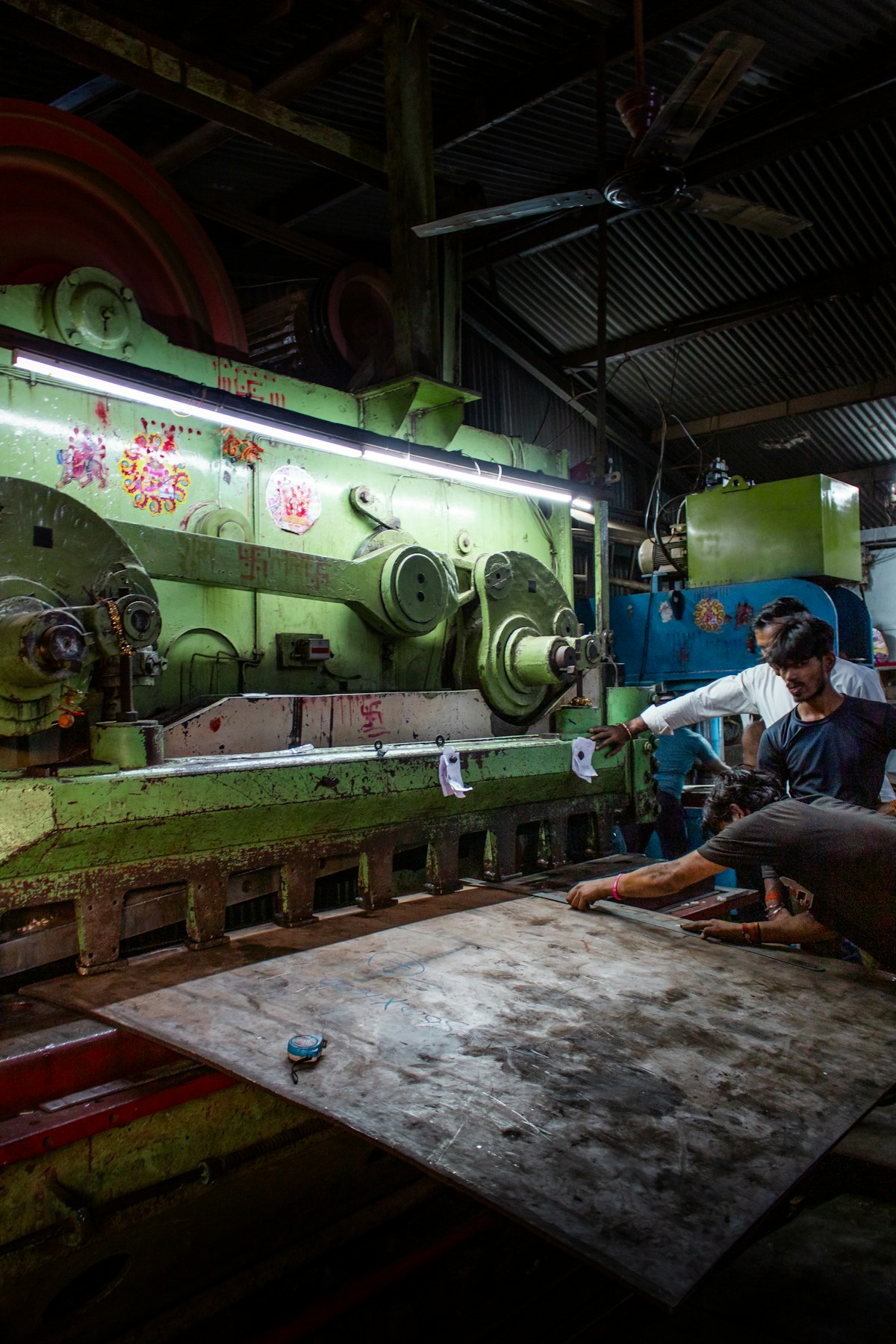 Workers operating heavy machinery in a factory representing manufacturing sector