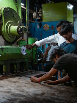 Workers operating heavy machinery in a factory.