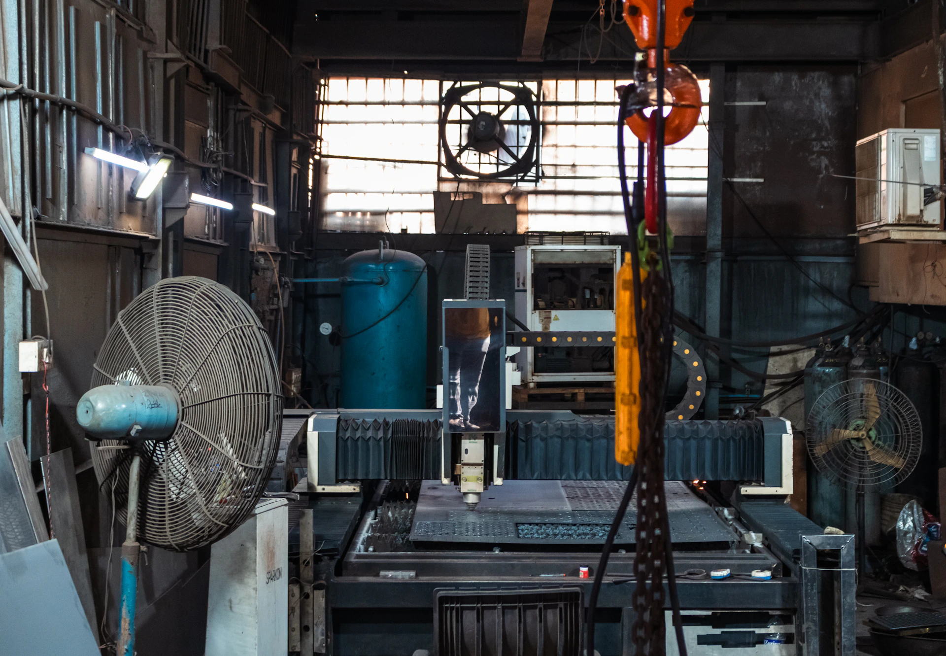 Industrial workshop with machinery and fans.