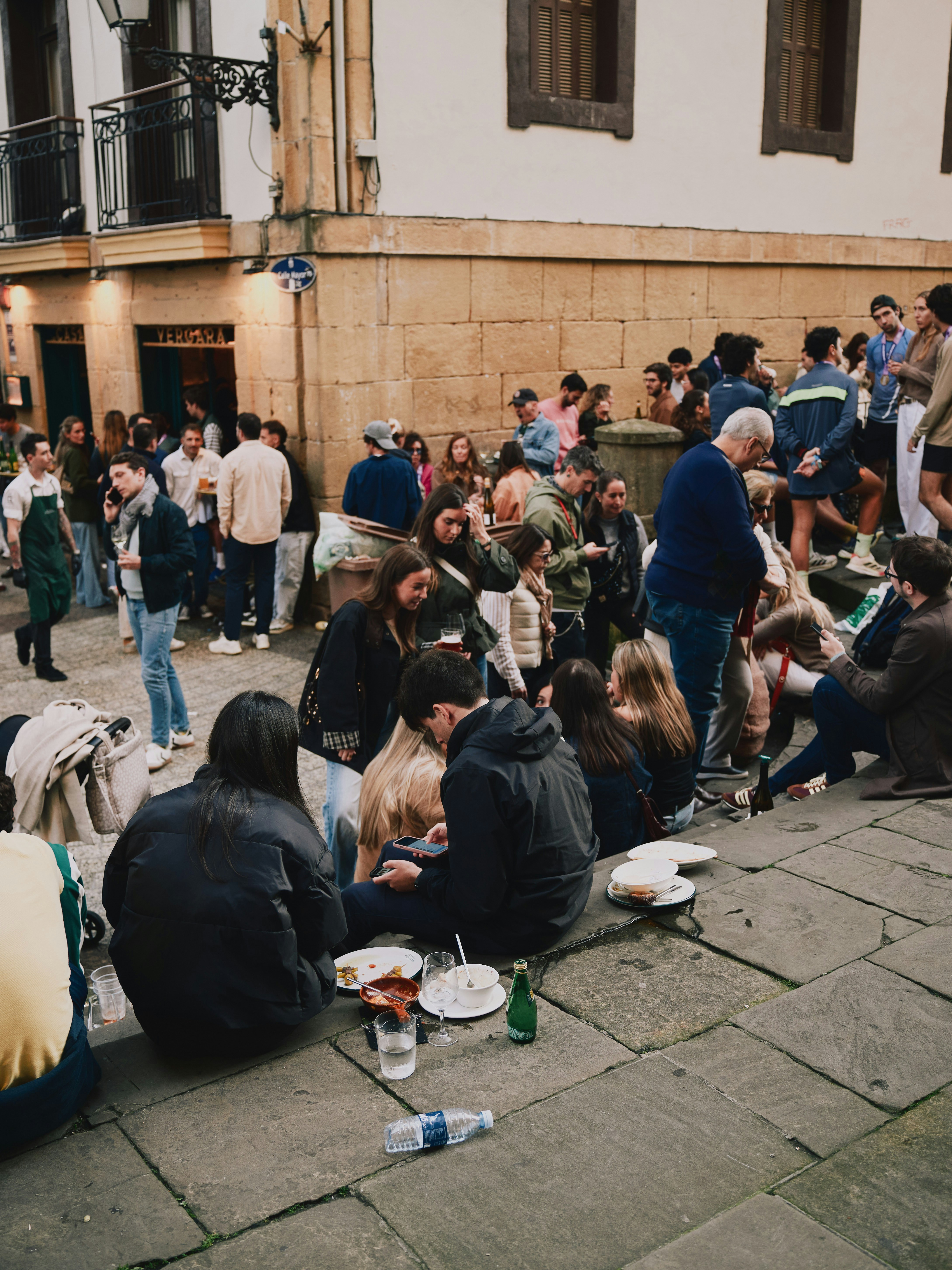 People gathered on stone steps eating and talking.
