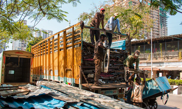 Men loading scrap metal onto a truck