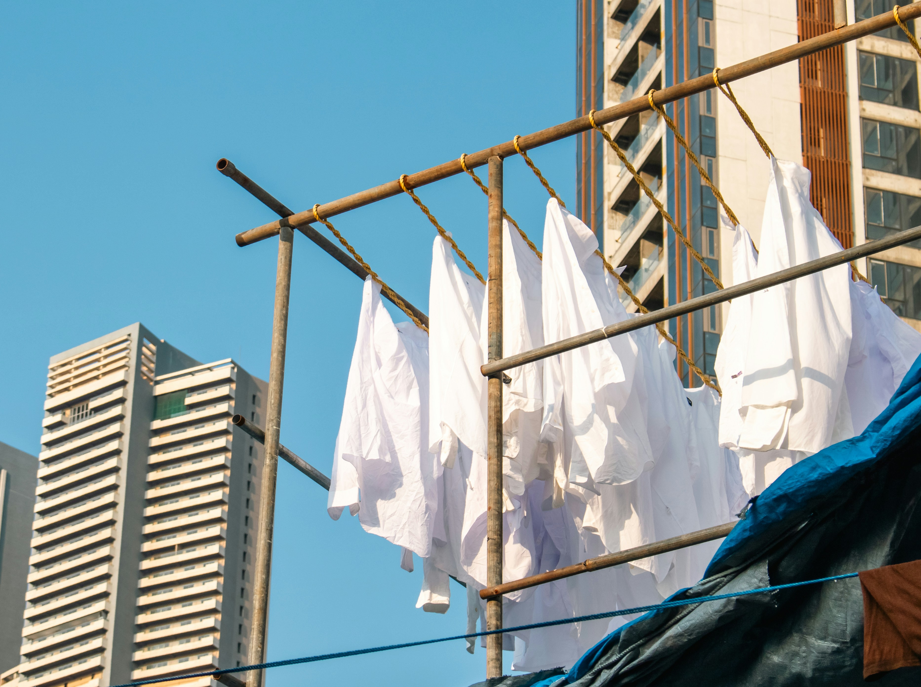 White clothes drying on a rack with buildings behind.