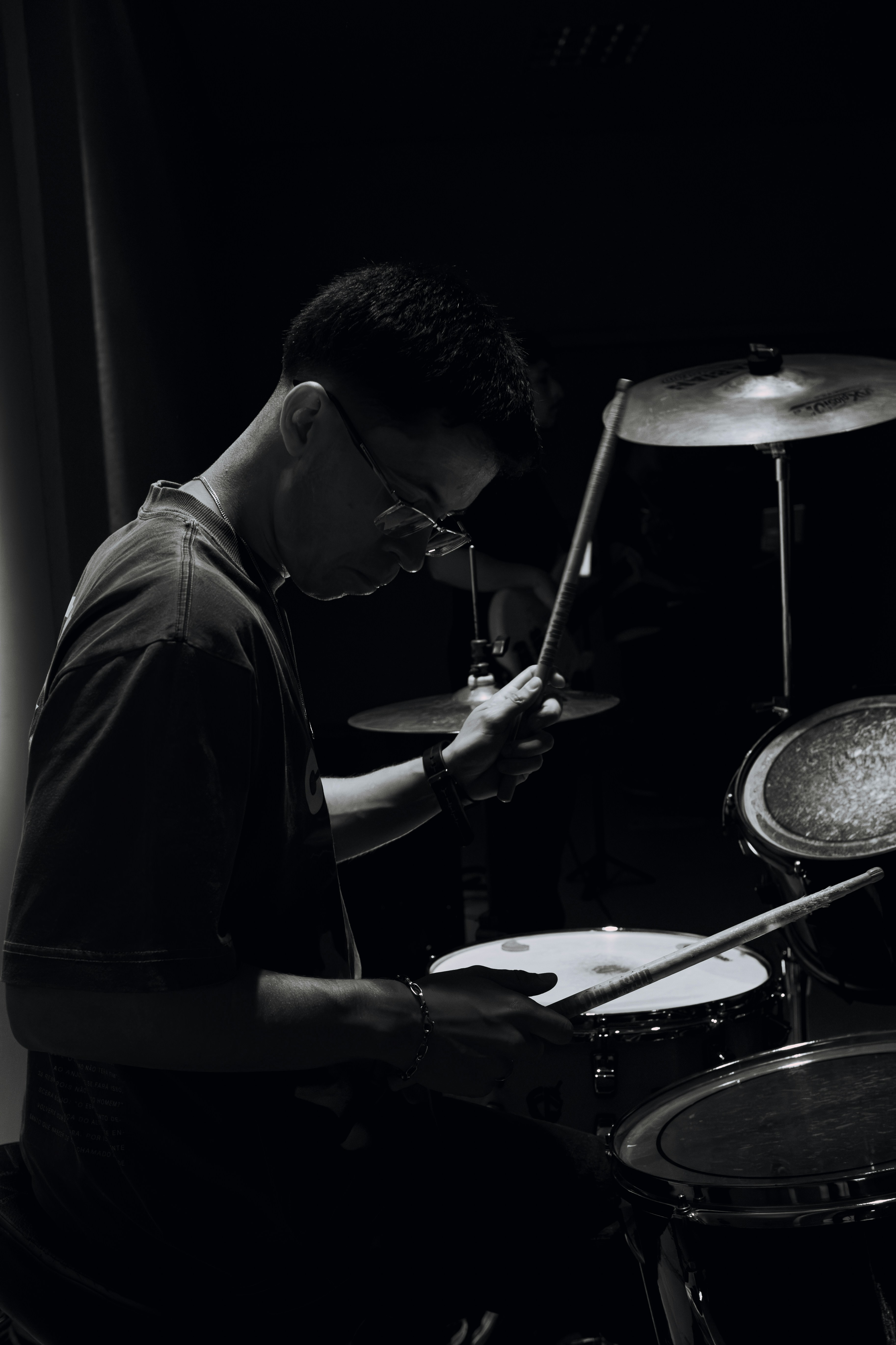 Man playing drums in a dark room