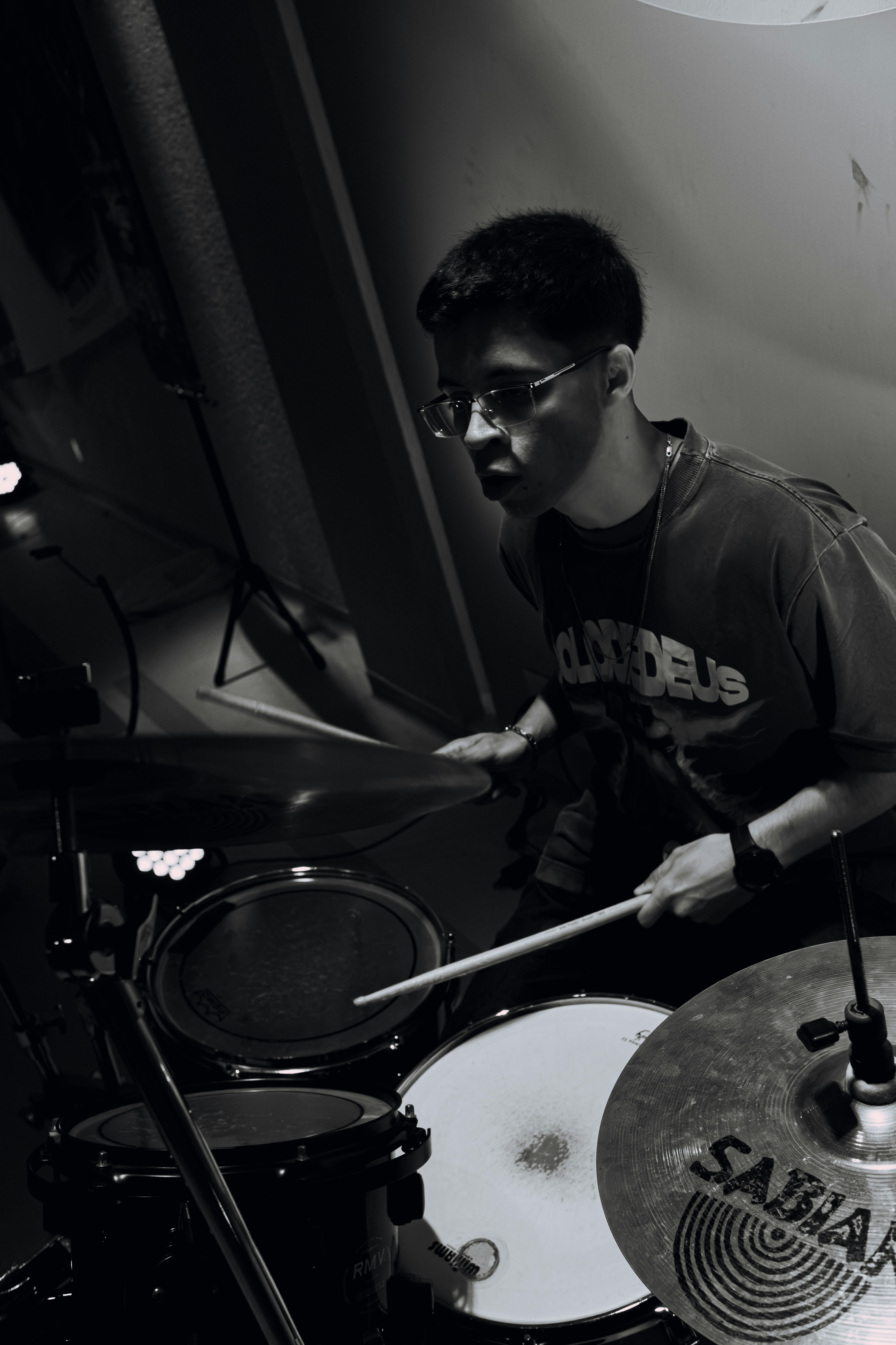 Young man playing drums with drumsticks