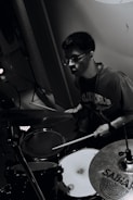 Young man playing drums with drumsticks