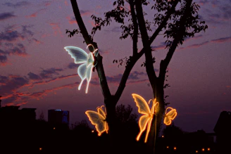 Glowing butterfly lights on a tree at dusk