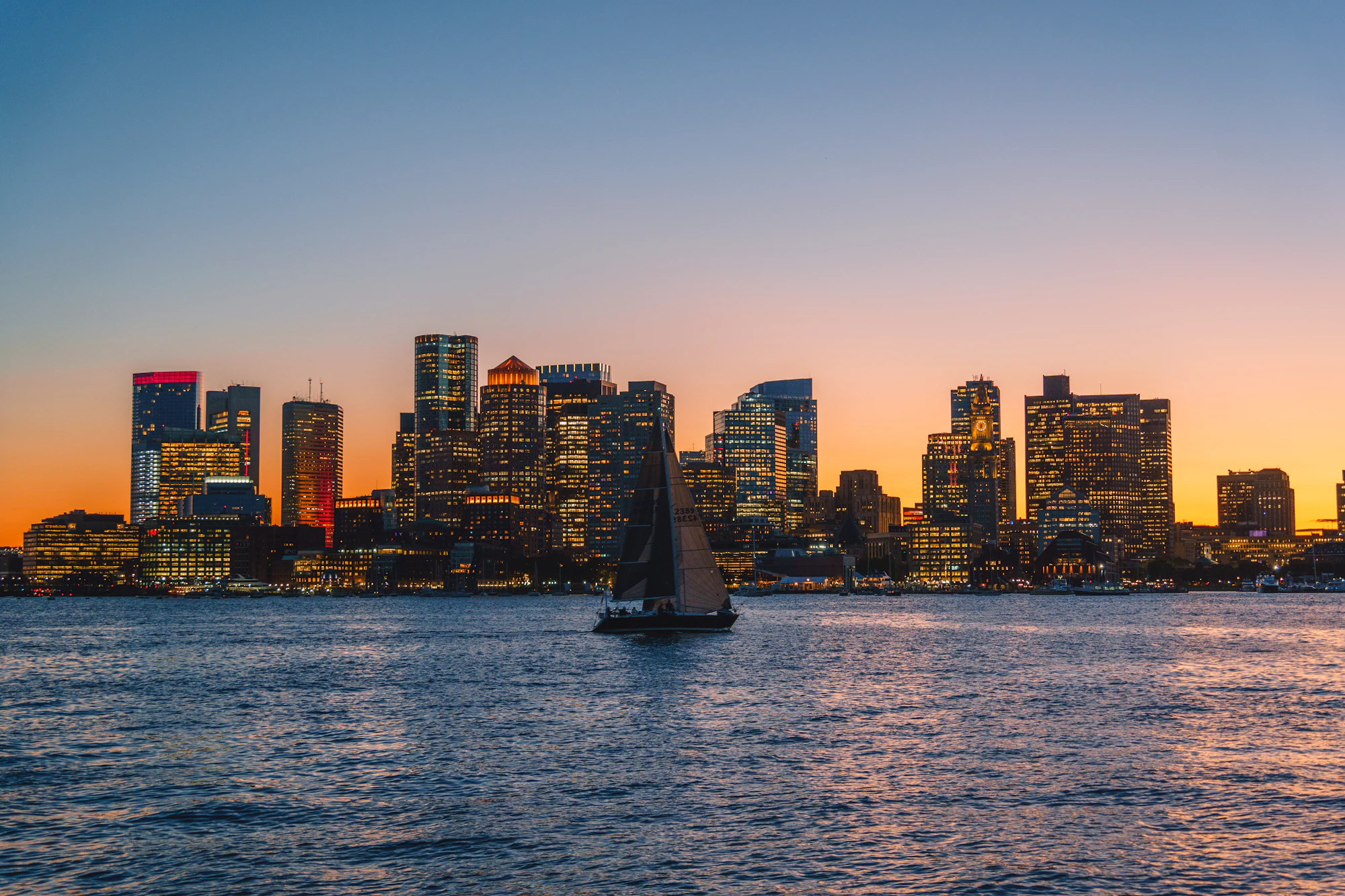 Boston skyline across the harbor at sunset