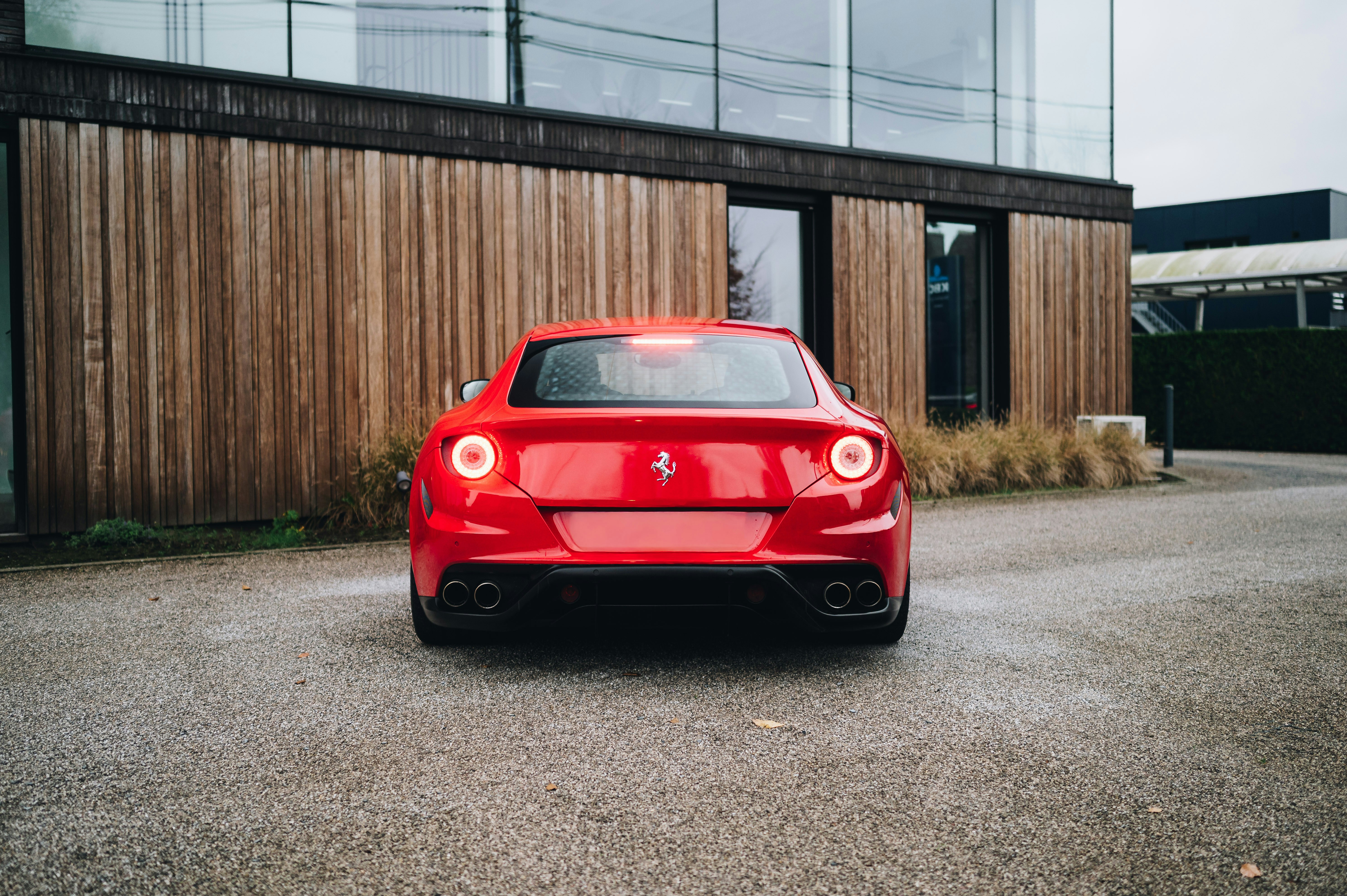 Roter Sportwagen vor dem modernen Gebäude geparkt
