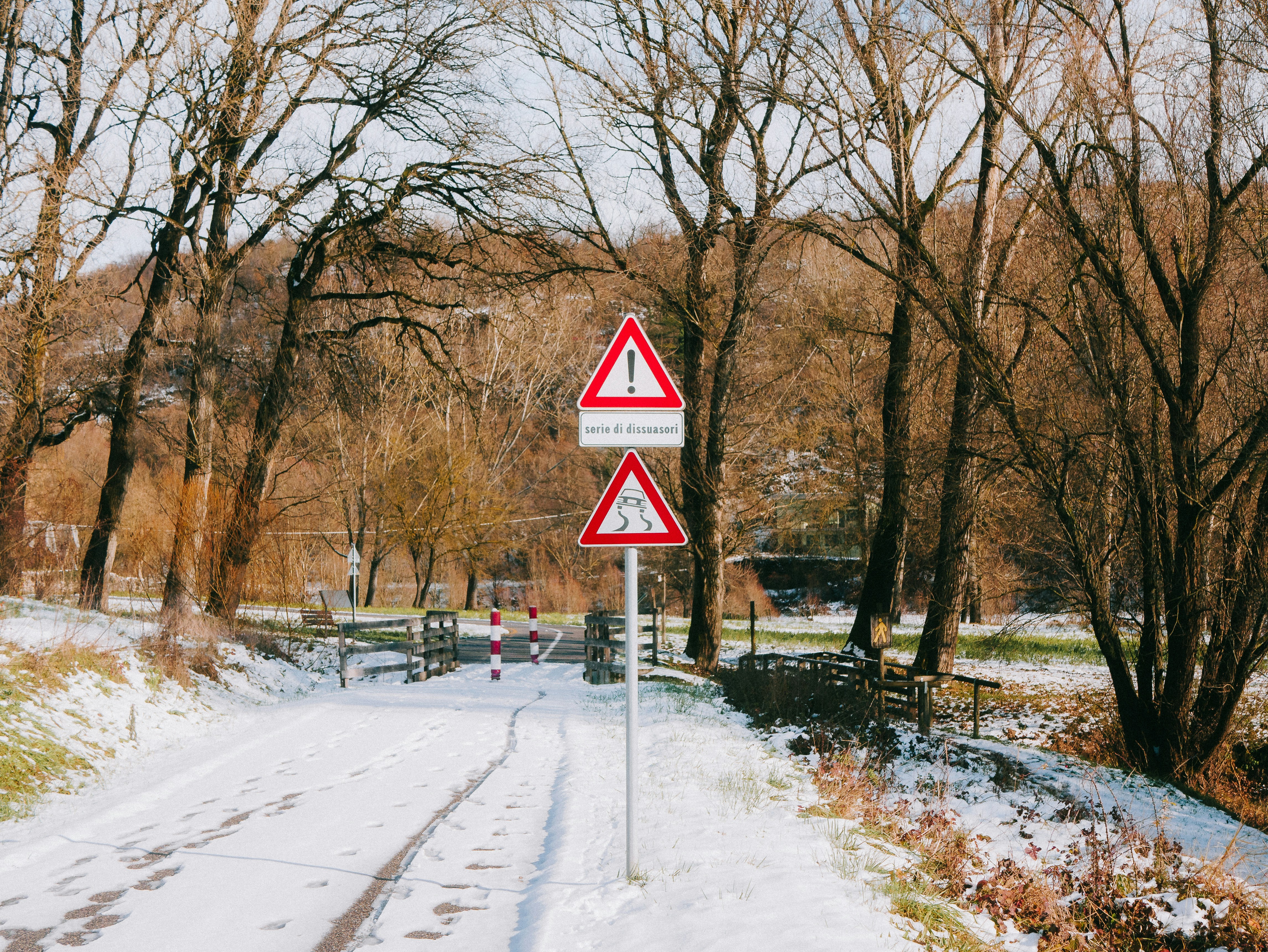 Two traffic signs on a snowy road