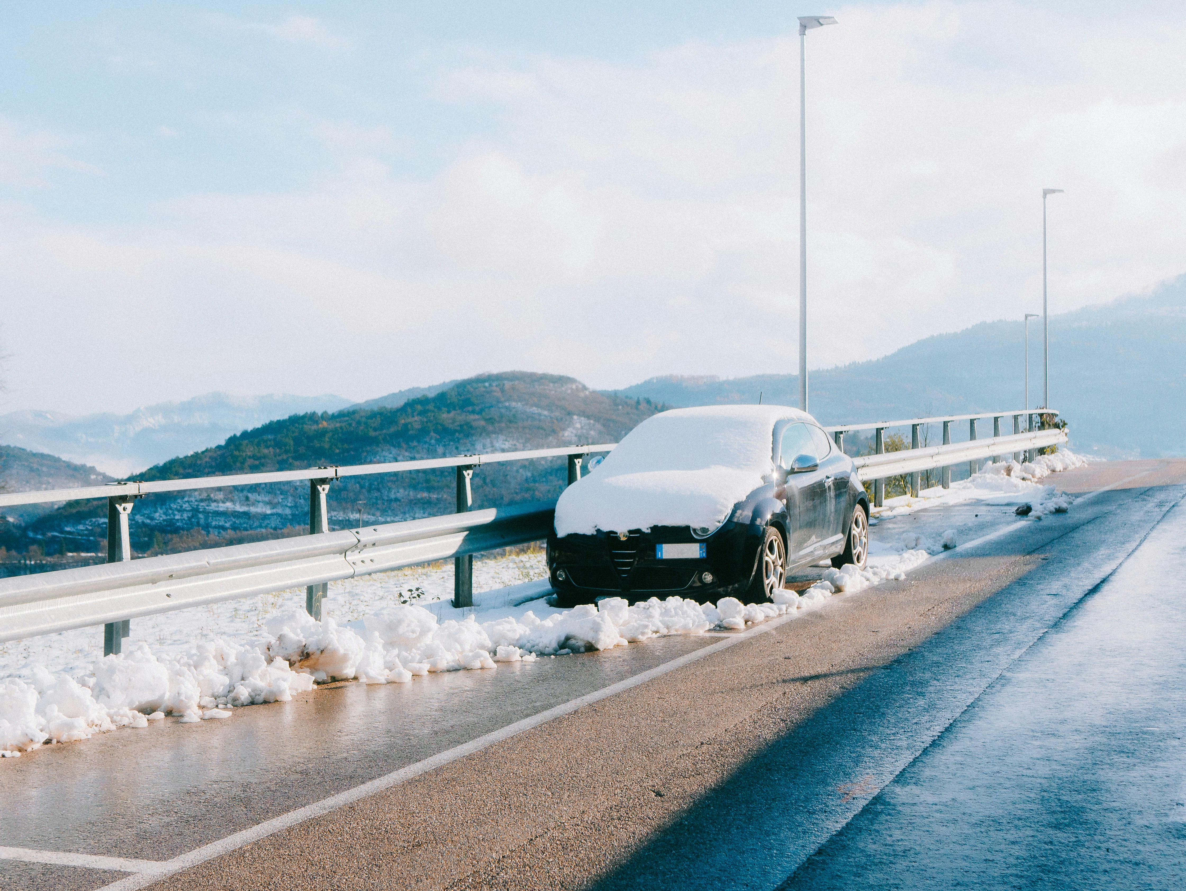 Car covered in snow on a winter road