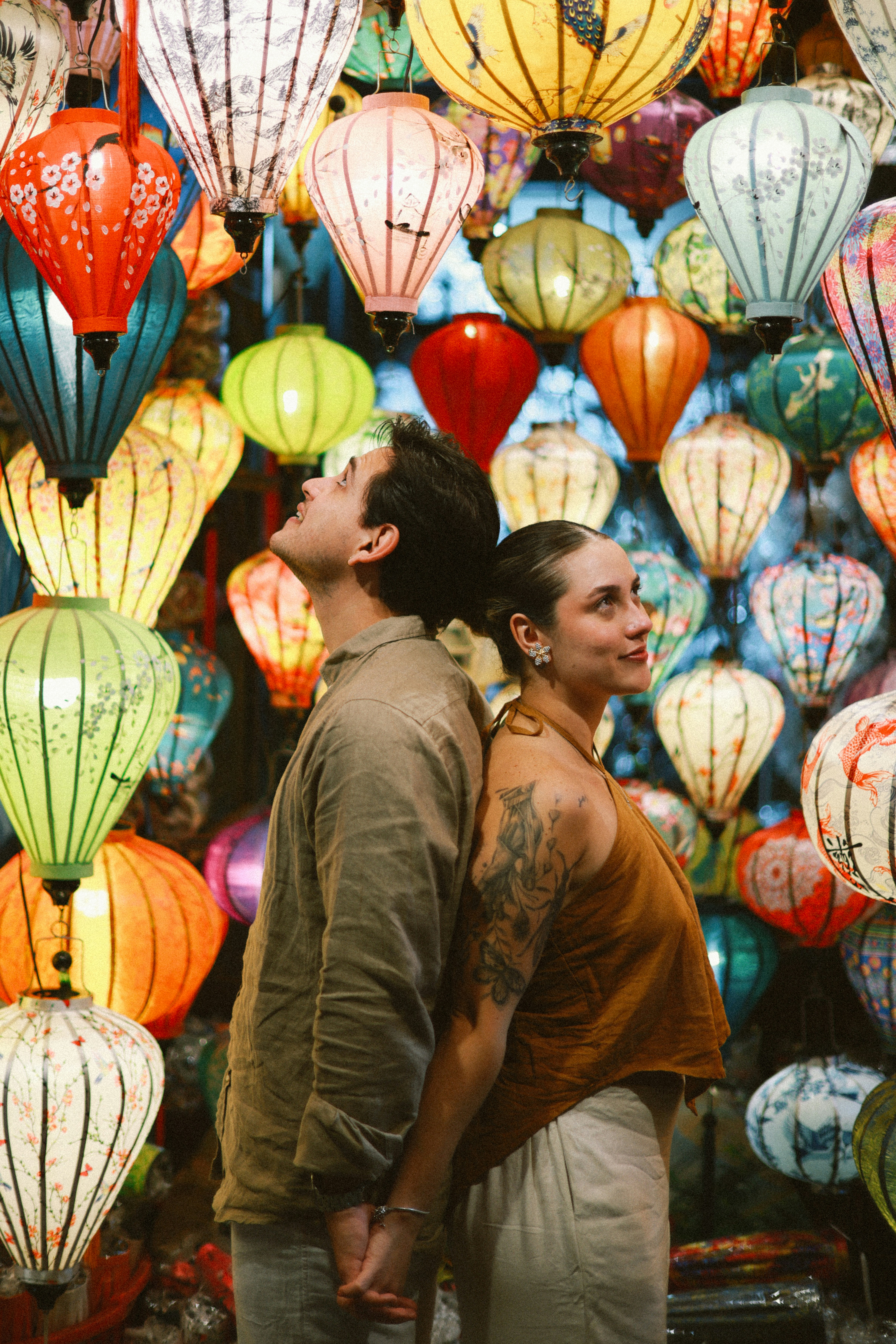 Couple holding hands surrounded by colorful lanterns