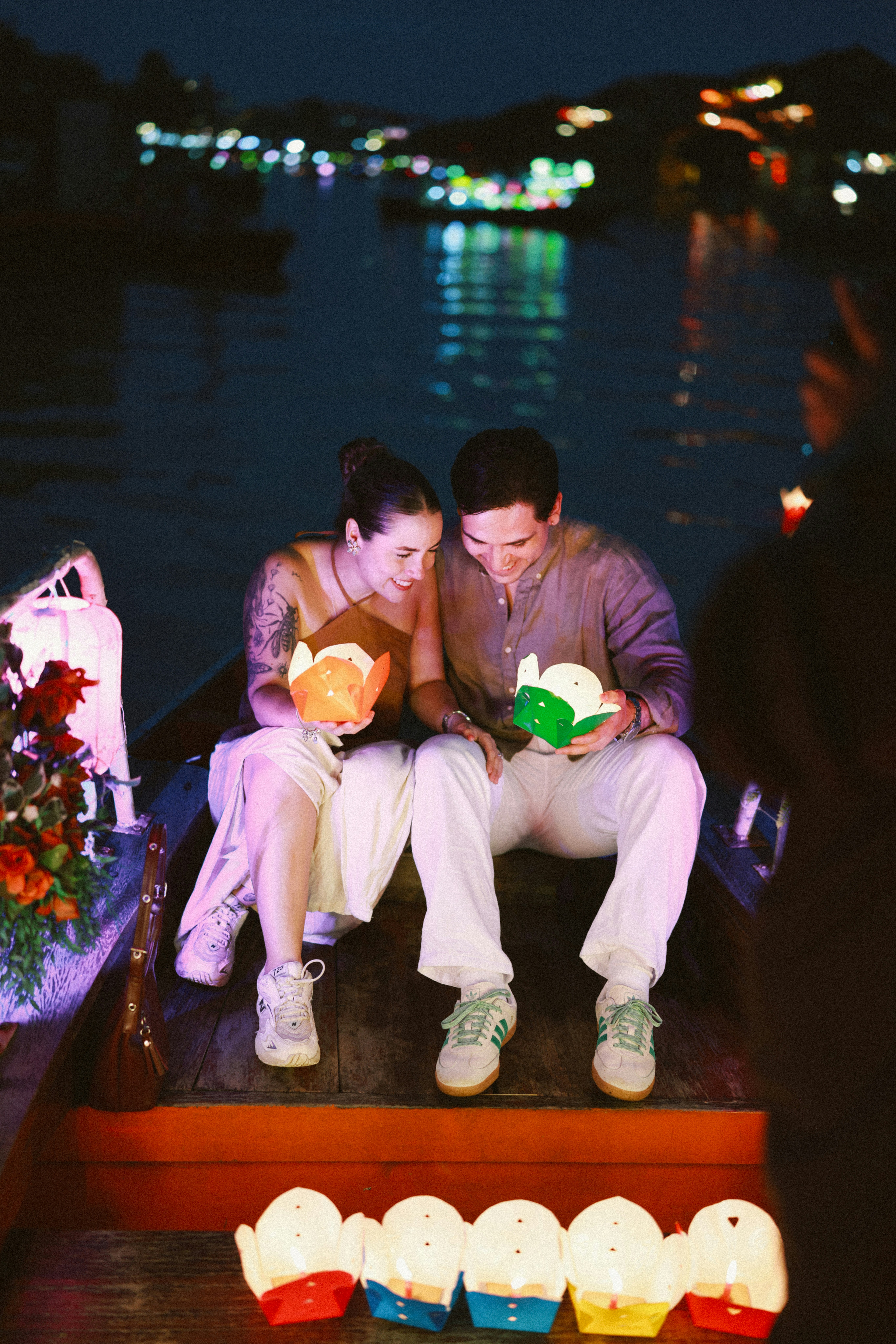 Paar, das nachts auf einem Boot Laternen hält, hält