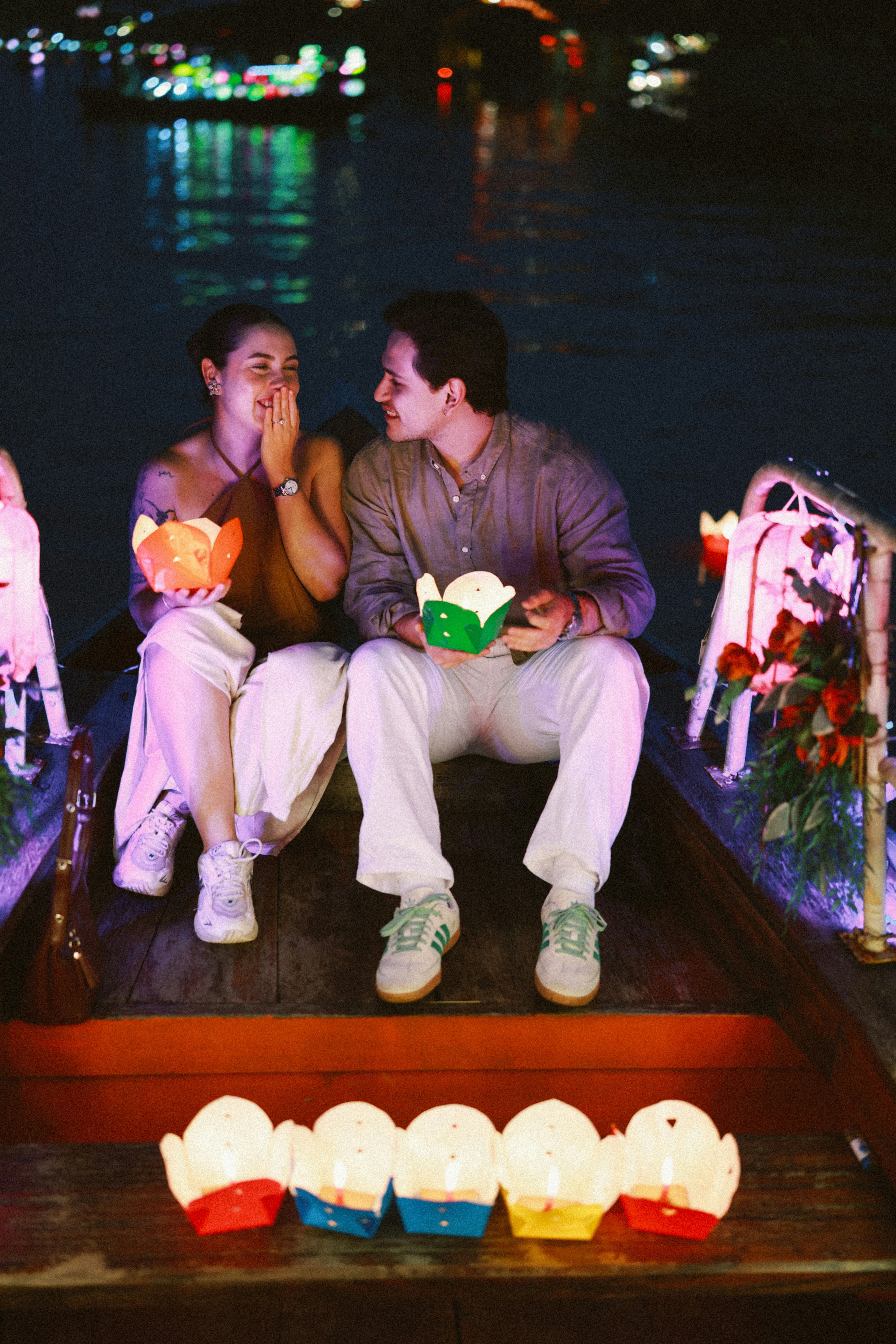 Paar nachts im Boot mit Laternen