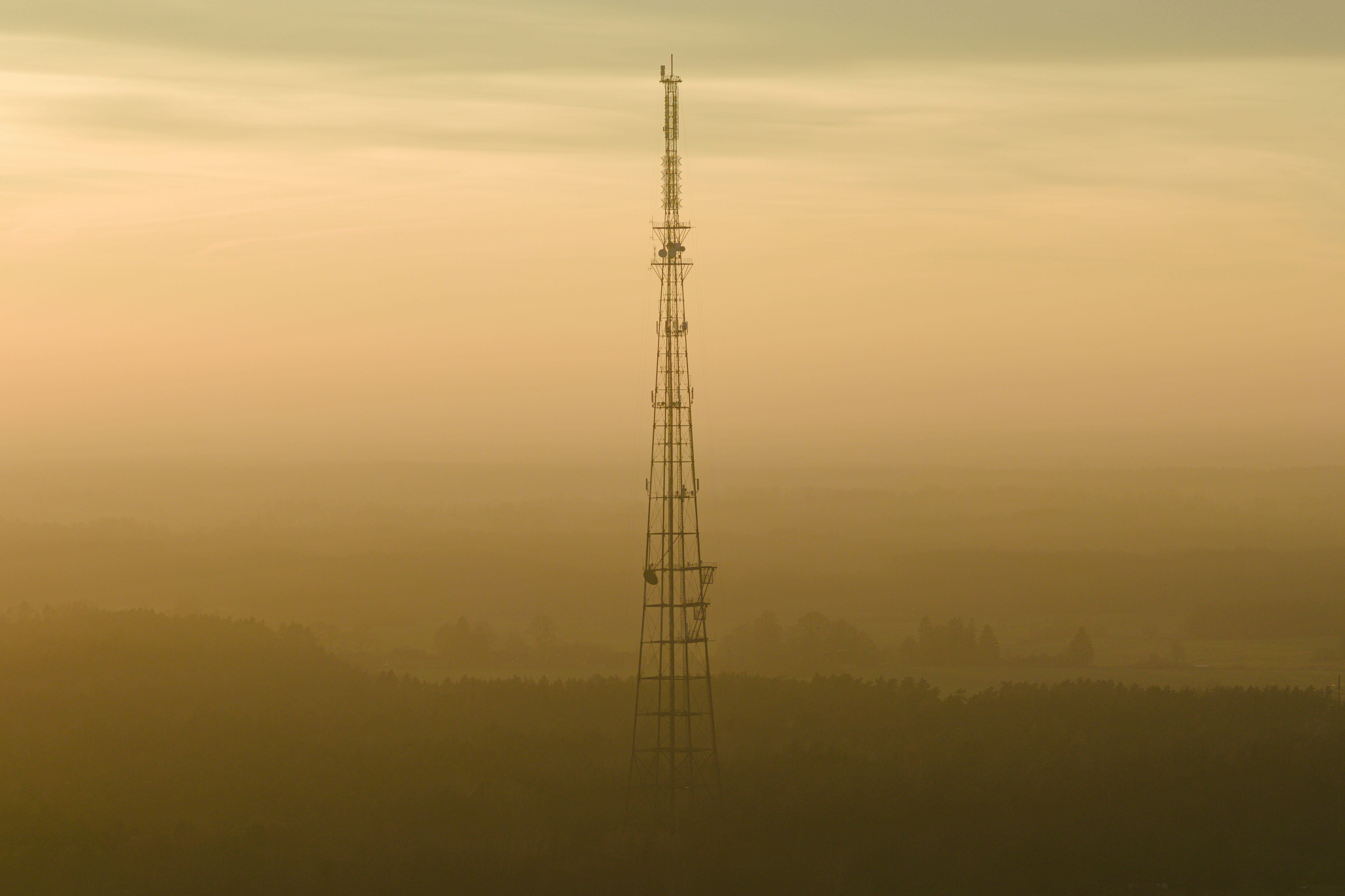 Alta torre de radio recortada contra un cielo brumoso