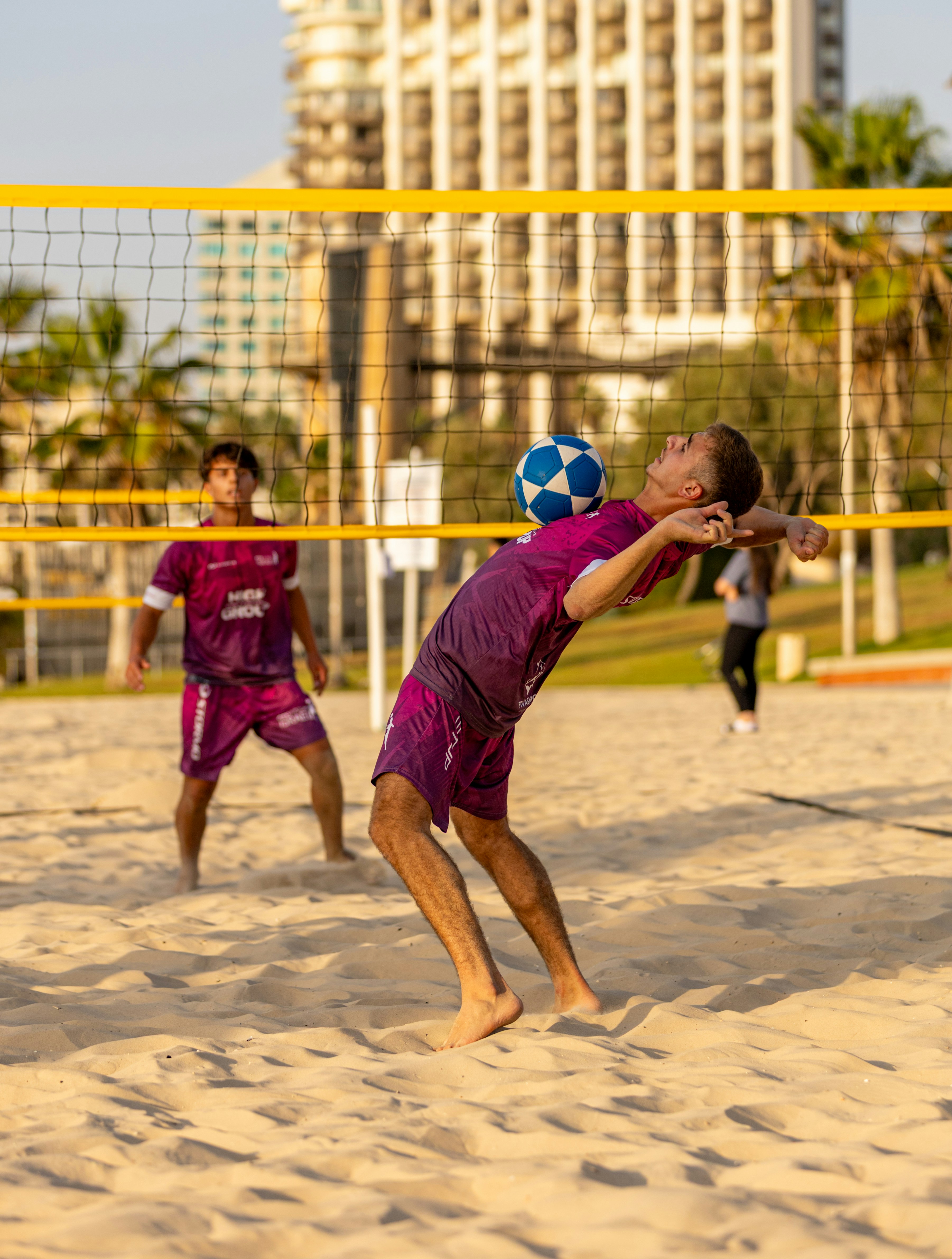 Man gioca a sepak takraw su un campo sabbioso.