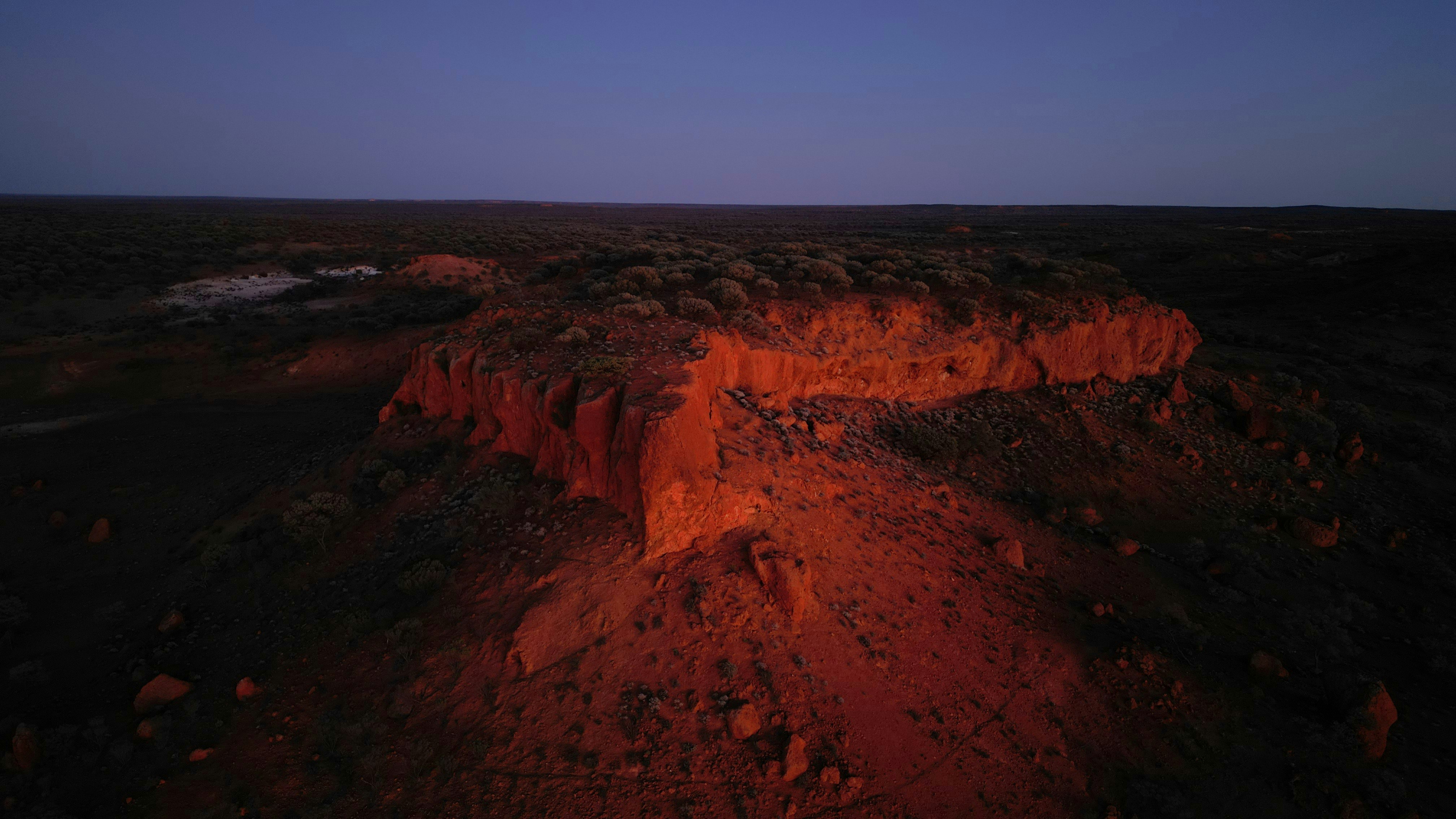 Canyon edge illuminated by sunset light at dusk