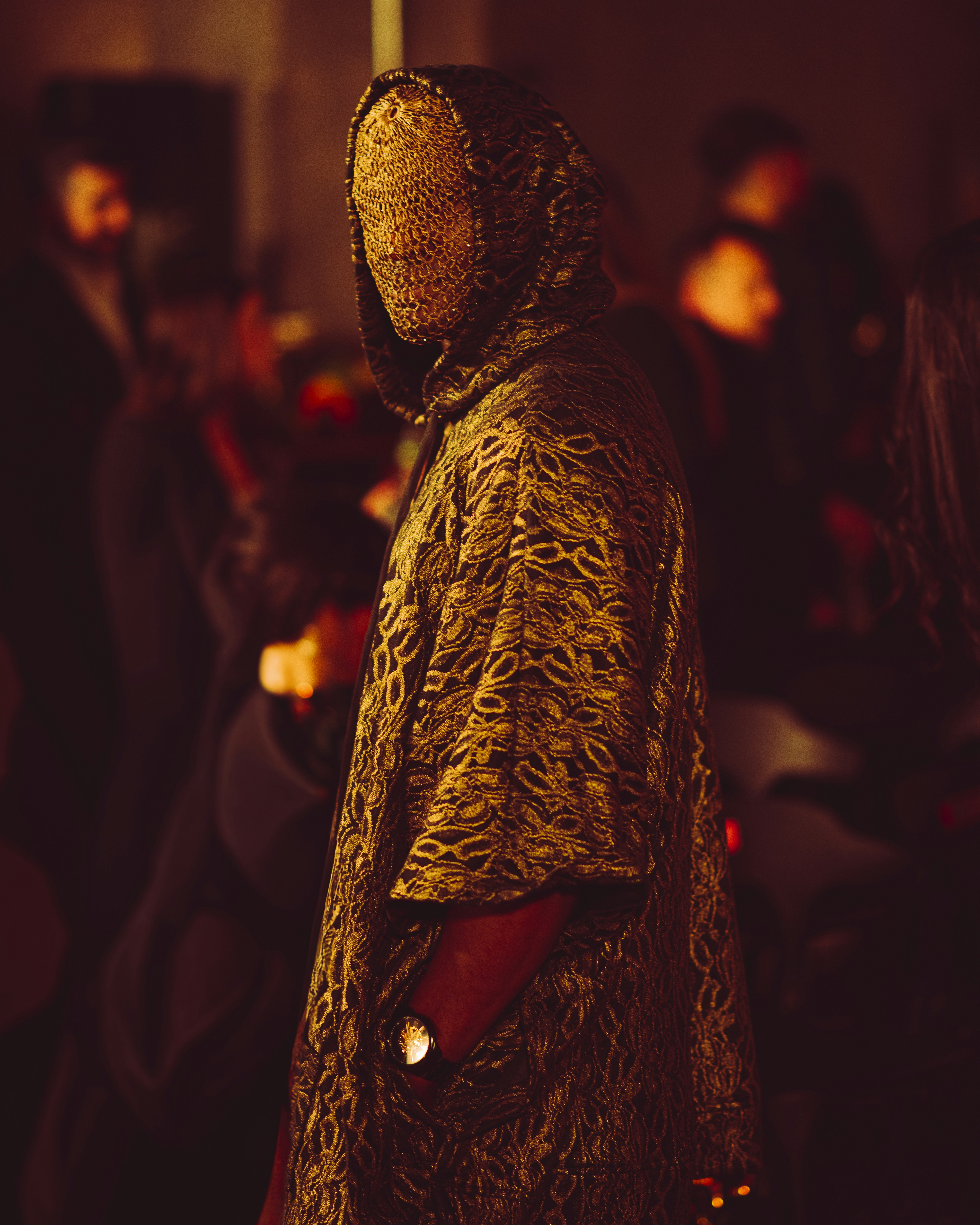 Person im Kapuzenumhang mit Muster und bedecktem Gesicht