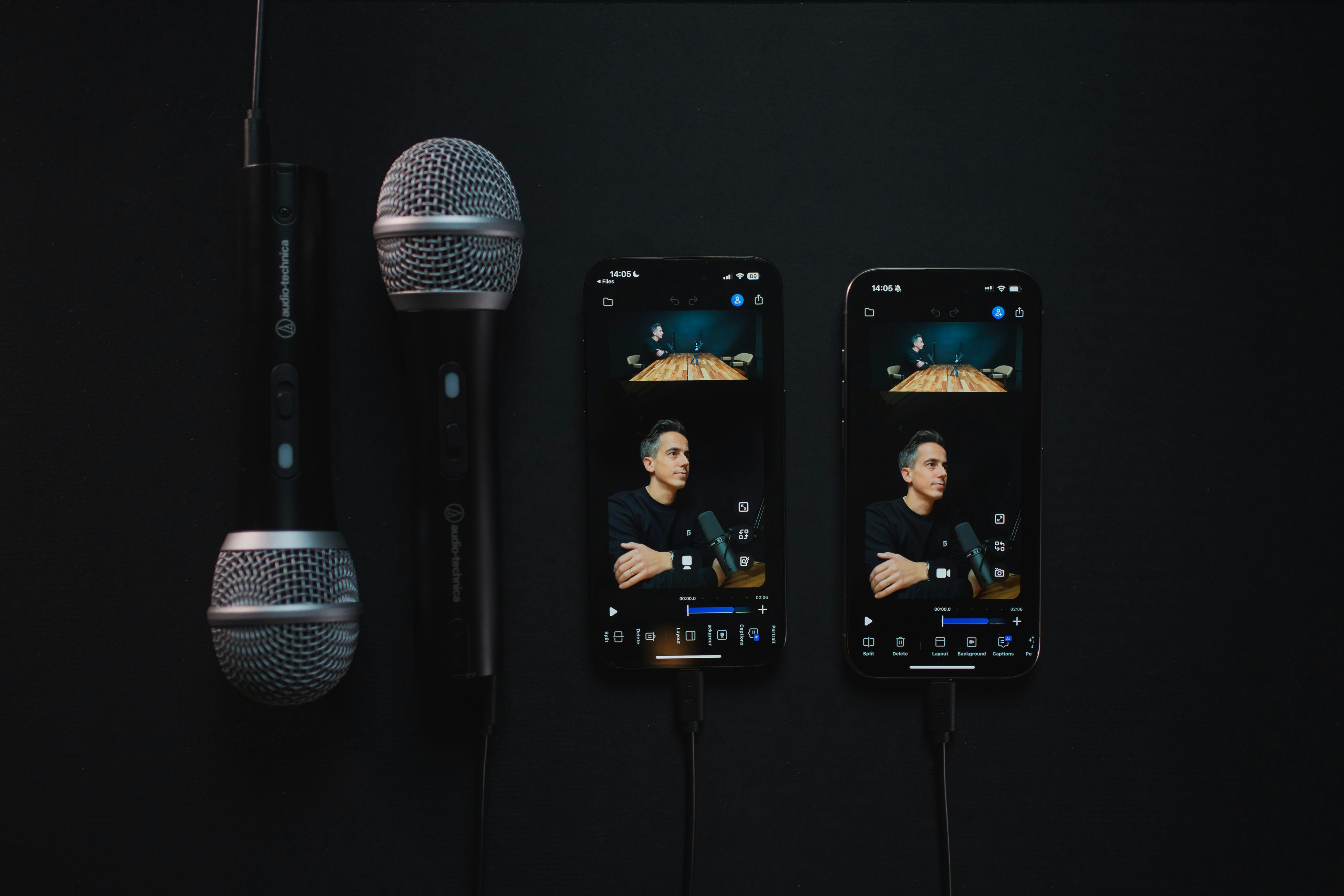 Two microphones and two phones displaying a person