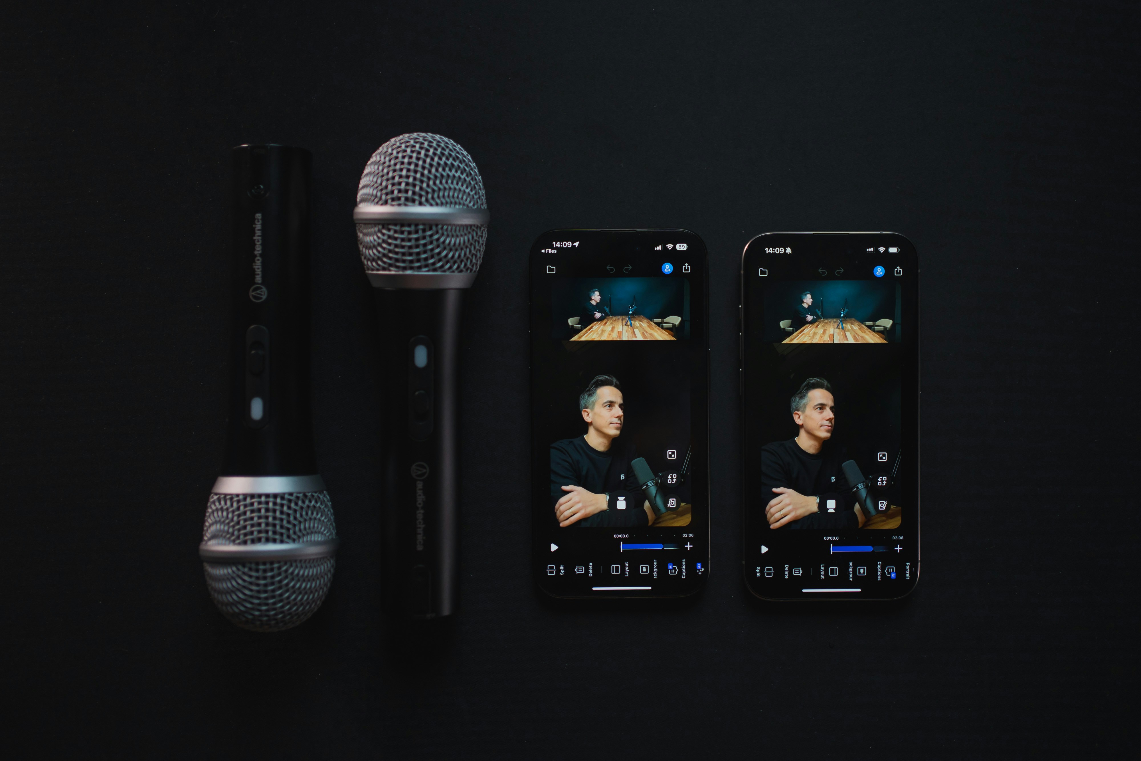 Two microphones and two smartphones displaying a podcast