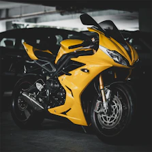 A bright yellow sport motorcycle parked indoors