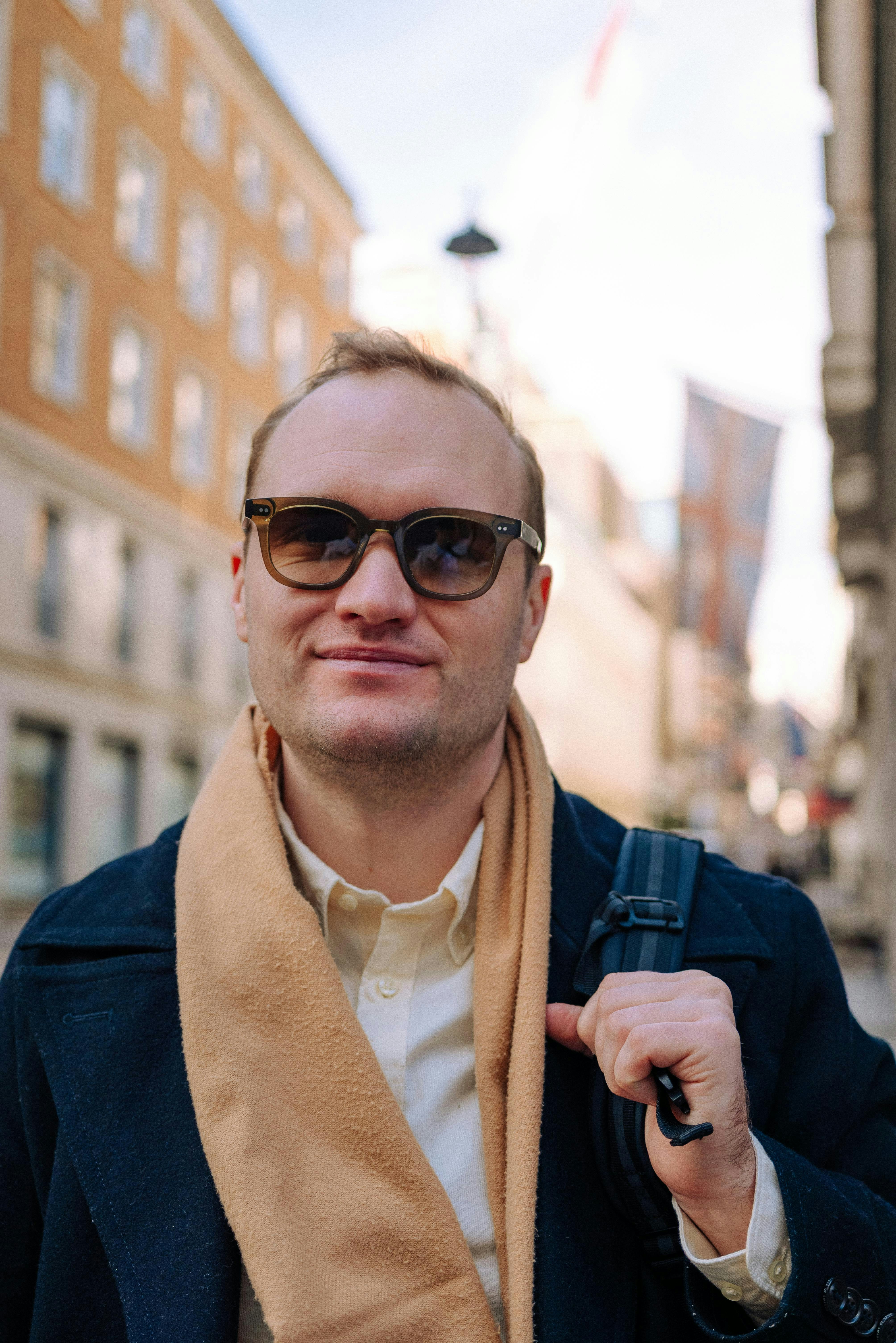 Man wearing sunglasses and scarf on city street