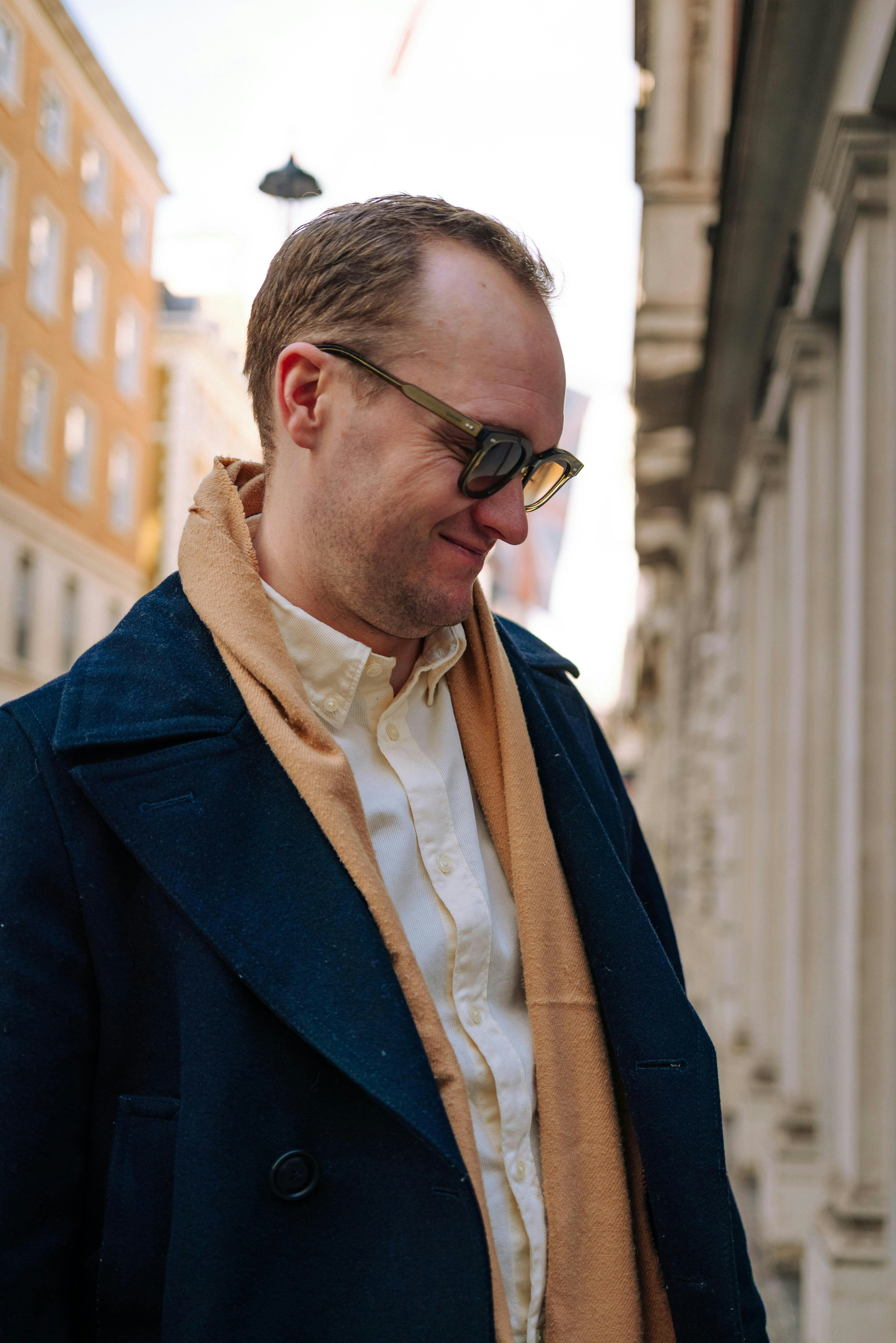 Man in coat and scarf looking down