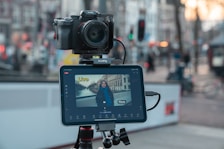 Camera and tablet on tripod filming city street