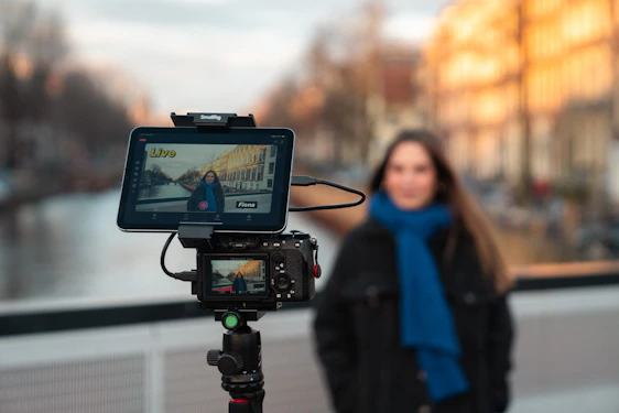 Camera setup with woman in background and canal