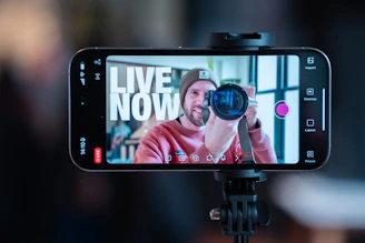 Man filming himself with a smartphone on a tripod.