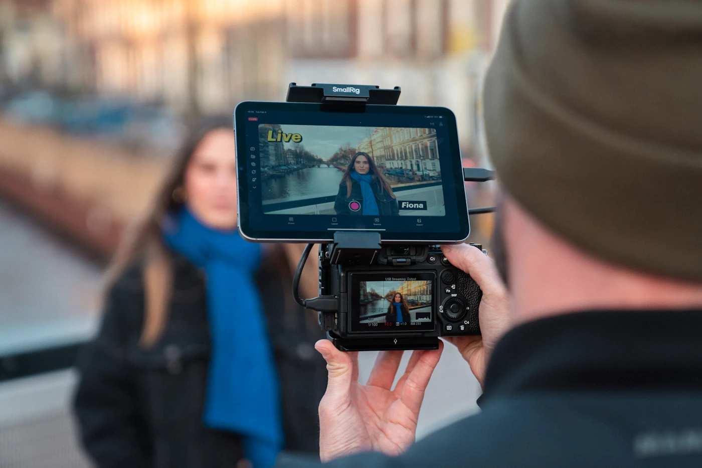 A camera operator records a woman during an outdoor live video production.