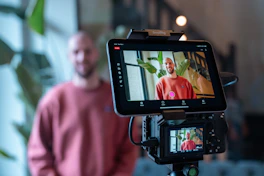 Man filming himself with a camera and tablet.
