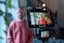 Man filming himself with a camera and tablet.